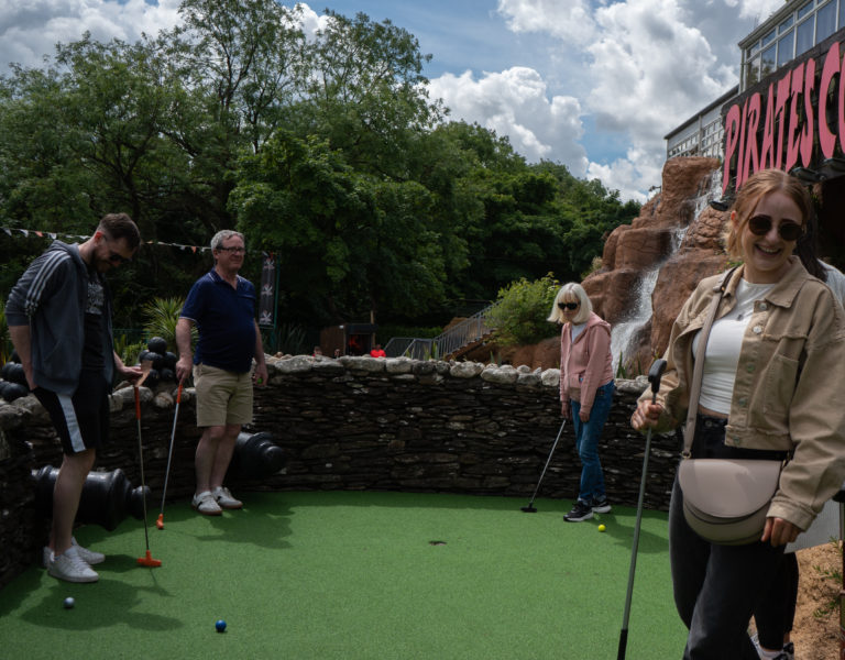 Group enjoying mini-golf at Piratemini-adventure course.