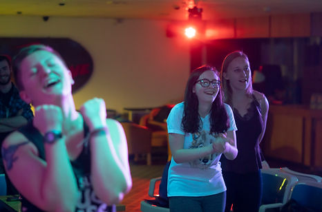 People enjoying a lively karaoke night in a colourful venue.